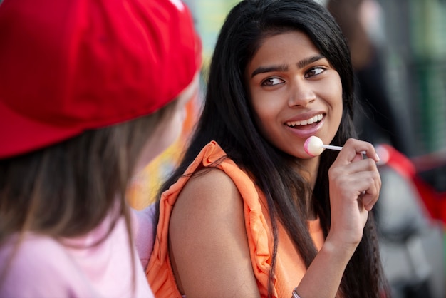 Cerca de adolescentes sonrientes con piruleta