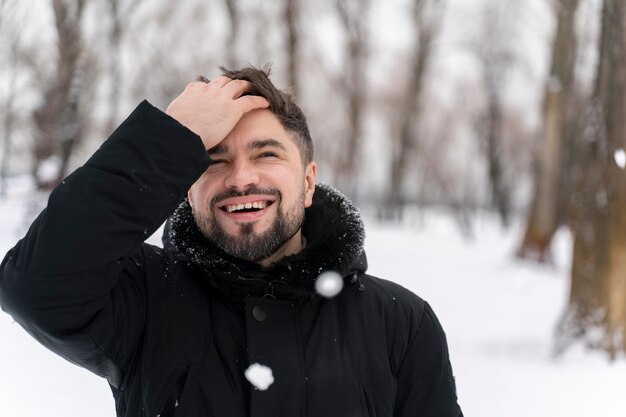 Cerca de adulto feliz jugando en la nieve.