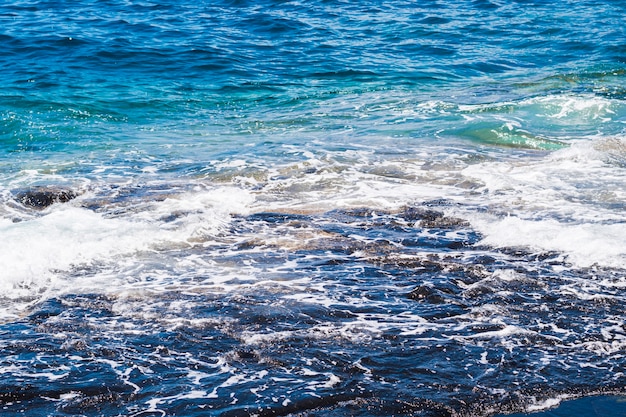 Cerca de agua cristalina ondulada en la playa