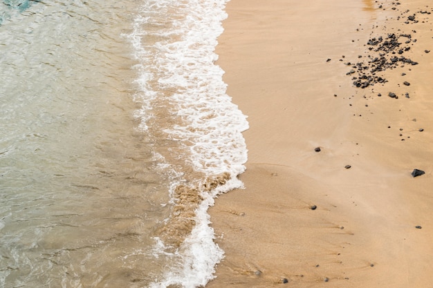 Cerca de agua de mar tocando arena en la orilla