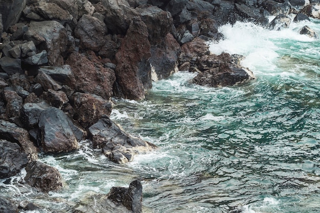 Cerca de agua ondulada en la costa rocosa