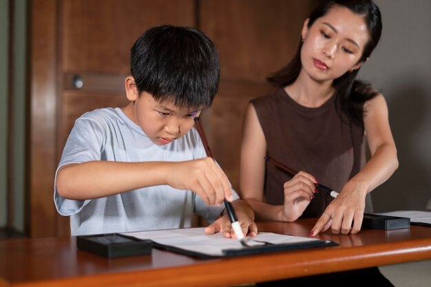 De cerca a los alumnos haciendo caligrafía japonesa, llamada shodo