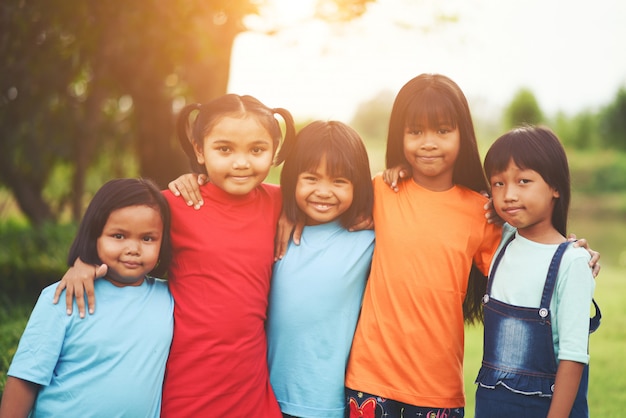 Cerca de los amigos de niña niño en un parque sonriendo a la cámara