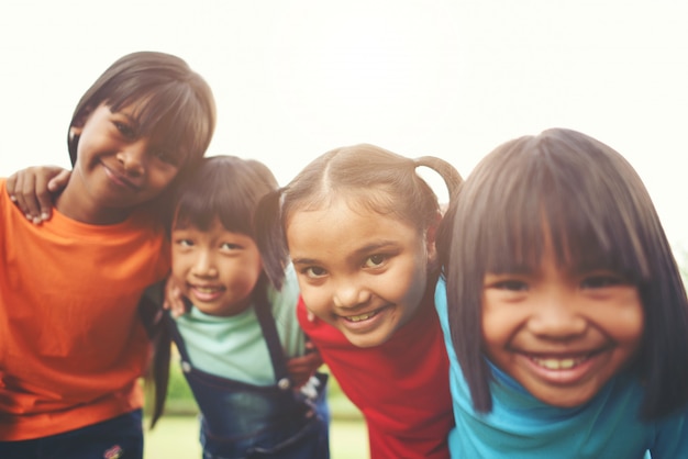 Foto gratuita cerca de los amigos de niña niño en un parque sonriendo a la cámara