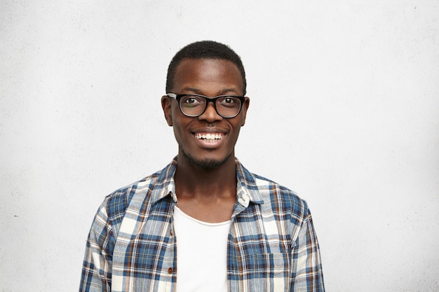 Cerca de atractivo atractivo aspecto sonriente modelo masculino de piel oscura posando