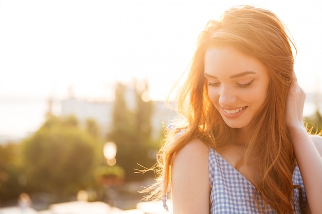 Foto gratuita cerca de una bella pelirroja mujer jugando con el pelo