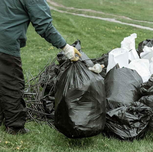 Cerca de bolsas de basura llenas de basura después de limpiar el medio ambiente