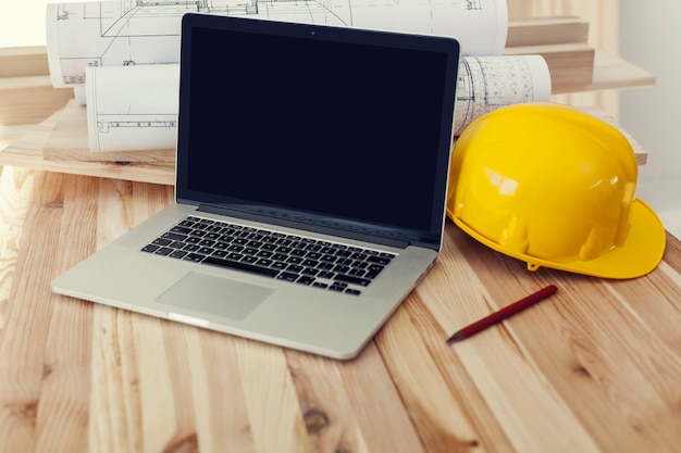 Cerca de la computadora portátil en el lugar de trabajo para el trabajador de la construcción