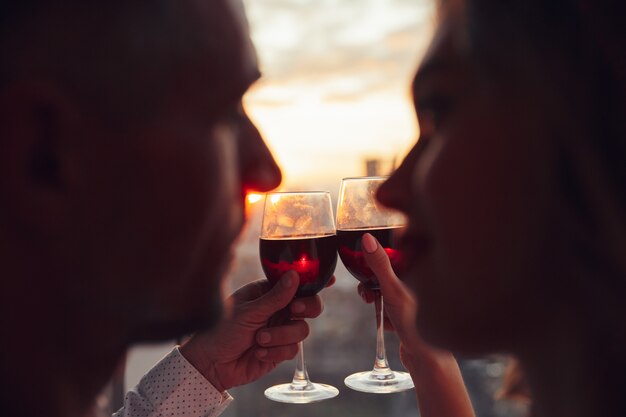 Cerca de copas con vino sosteniendo por amantes