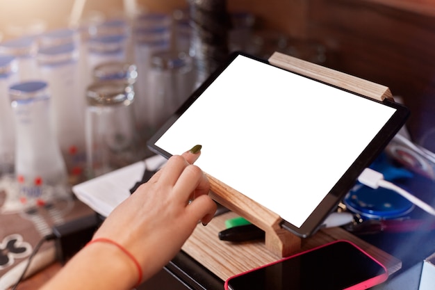 Cerca del dedo barista con desplazamiento de manicura tablet pc en el café