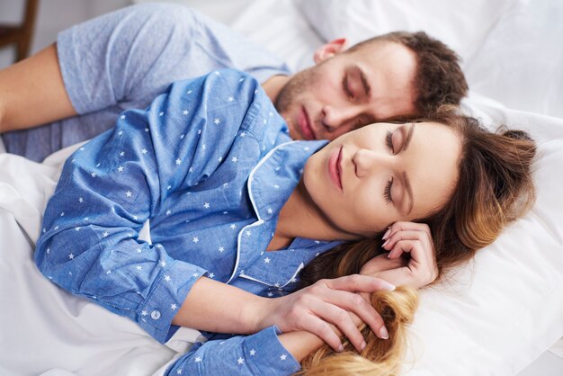 Cerca de dormir juntos pareja en la cama