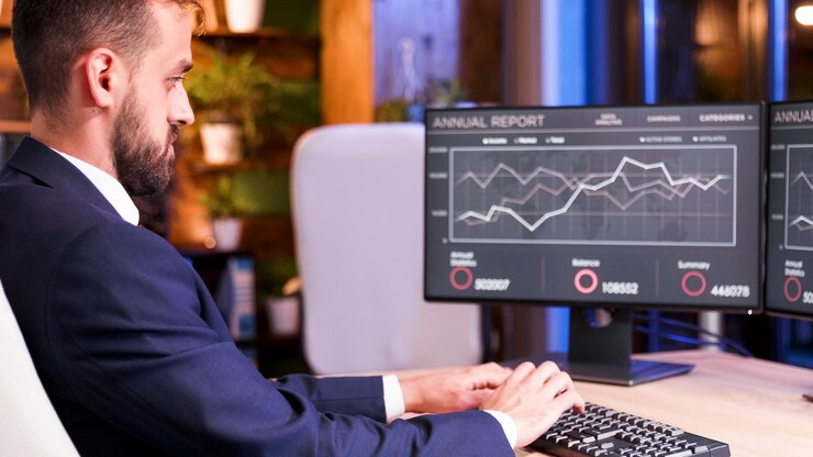 Foto gratuito de cerca con el empresario parcheando algo en el teclado. gráficos en el monitor