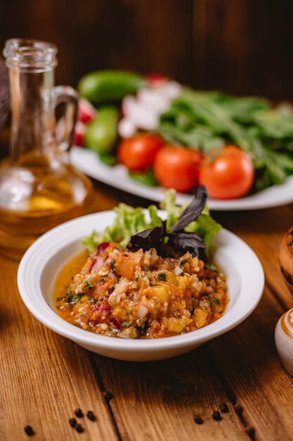 Cerca de ensalada de berenjenas a la plancha con tomate pimiento cebolla y hierbas