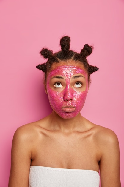 Foto gratuita cerca de feliz mujer étnica disfruta aplicando mascarilla aislada