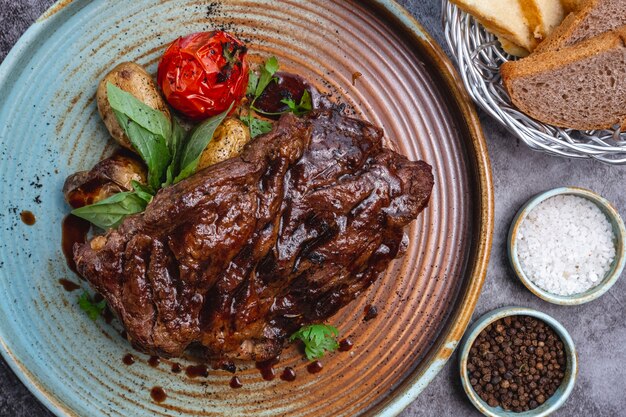 Cerca de filete de res cocinado con sauc, papas baby y tomate