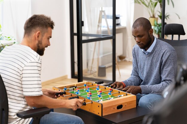 De cerca a la gente que se divierte jugando al fútbol de mesa