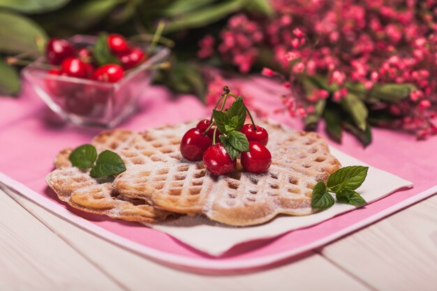 Cerca de gofres dulces con cerezas