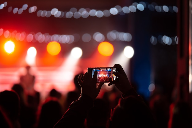 Foto gratuita cerca de la grabación de video con el teléfono inteligente durante un concierto. imagen entonada