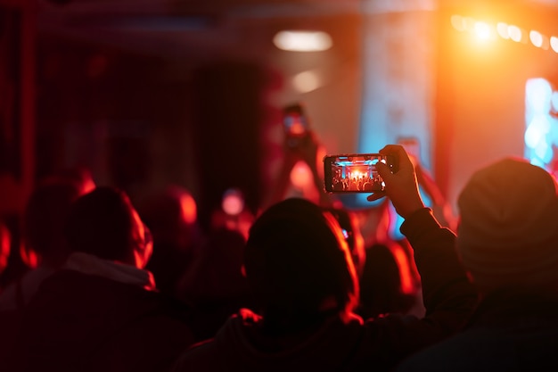 Cerca de la grabación de video con el teléfono inteligente durante un concierto.