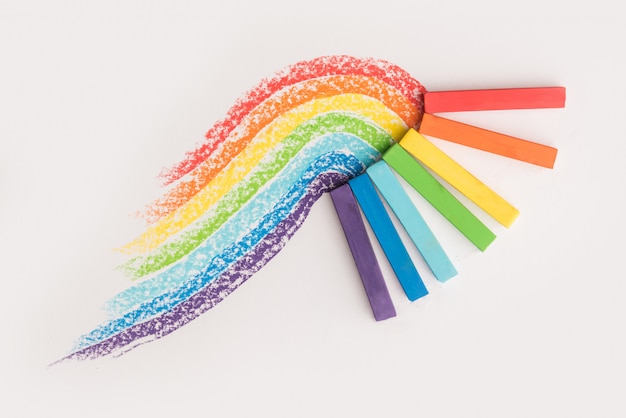 Cerca del gradiente de arco iris hecho de tizas de crayón pastel sobre las huellas coloridas