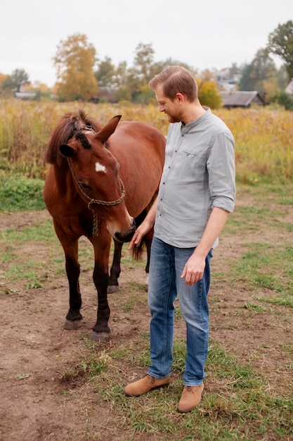 Cerca de granjero con hermoso caballo