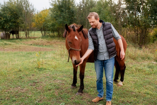 Cerca de granjero con hermoso caballo