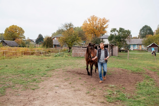 Cerca de granjero con hermoso caballo