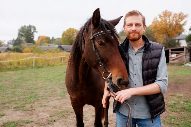 Cerca de granjero con hermoso caballo