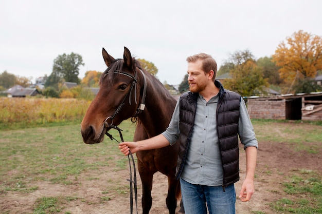 Cerca de granjero con hermoso caballo