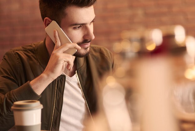 Cerca del hombre llamando en el bar cafetería