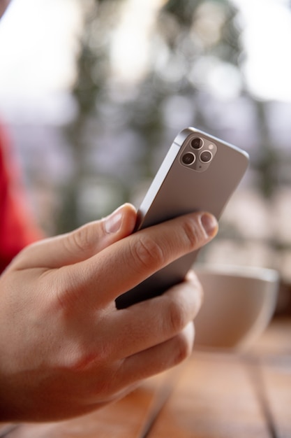 Foto gratuita cerca del hombre mediante teléfono móvil inteligente aislado en la pared blanca. estilo de vida, concepto de tecnologías modernas.