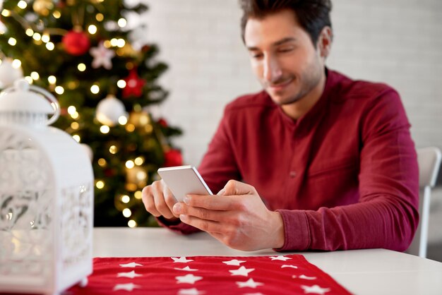 Cerca del hombre mediante teléfono móvil en Navidad