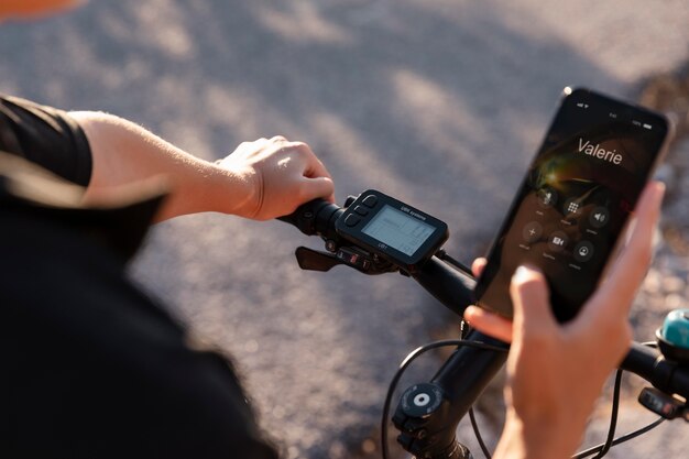 Cerca del hombre usando el teléfono mientras está en bicicleta eléctrica