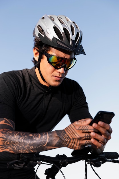 Cerca del hombre usando el teléfono mientras está en bicicleta eléctrica