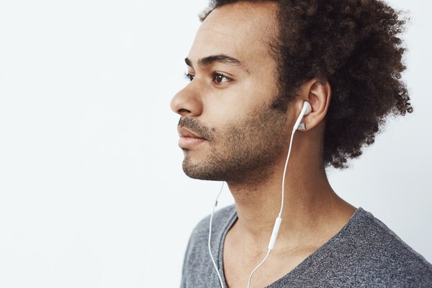 Cerca del joven africano escuchando música en auriculares.