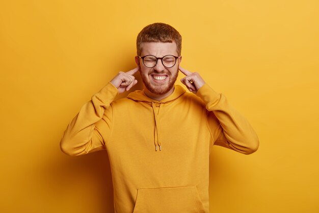 Cerca de joven barbudo con gafas aisladas