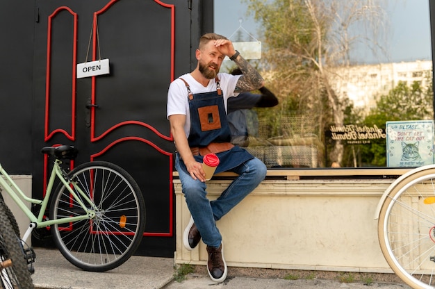 Cerca de joven empresario en tienda de bicicletas