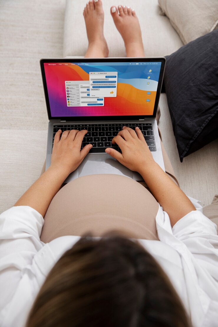 Foto gratuito cerca de la joven mujer embarazada que trabaja en la computadora portátil