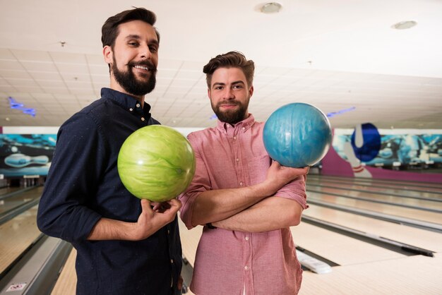 Cerca de jóvenes amigos disfrutando de los bolos