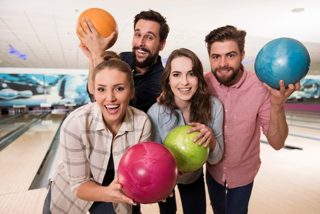 Cerca de jóvenes amigos disfrutando de los bolos