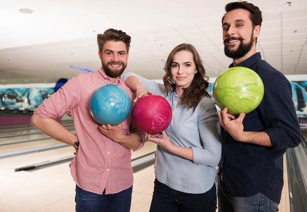 Cerca de jóvenes amigos disfrutando de los bolos