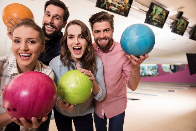 Cerca de jóvenes amigos disfrutando de los bolos