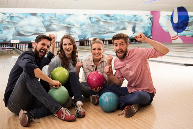 Cerca de jóvenes amigos disfrutando de los bolos