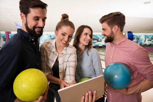 Cerca de jóvenes amigos disfrutando de los bolos