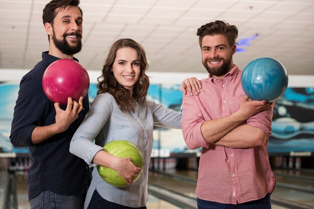 Cerca de jóvenes amigos disfrutando de los bolos