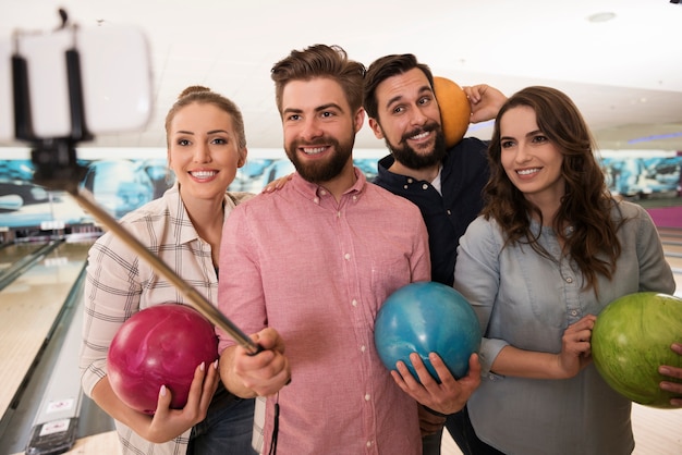 Cerca de jóvenes amigos disfrutando de los bolos