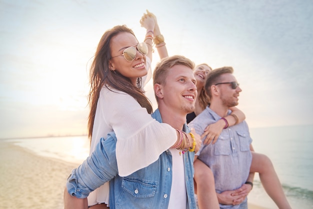 Cerca de jóvenes amigos divirtiéndose en la playa