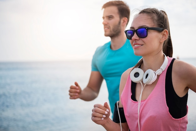 Cerca de jóvenes en forma trotar junto al mar