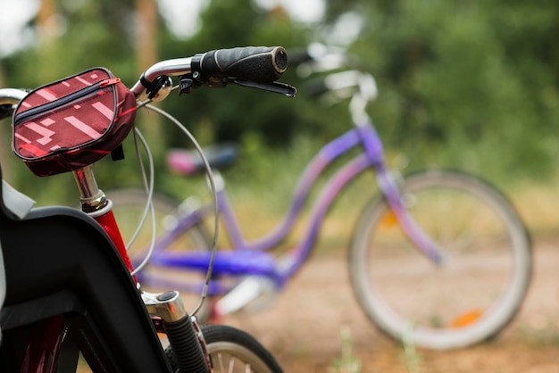 Cerca del manillar de la bicicleta con la bicicleta desenfocada