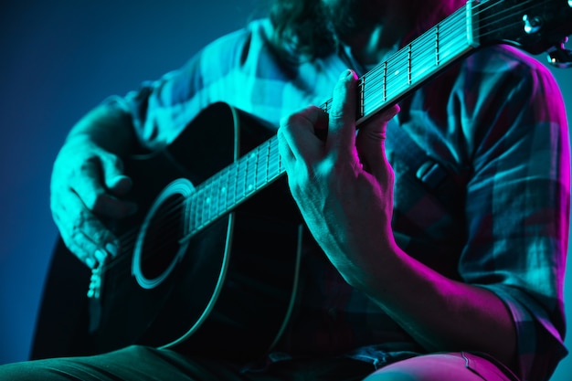 Cerca de la mano del guitarrista tocando la guitarra copyspace macro shot